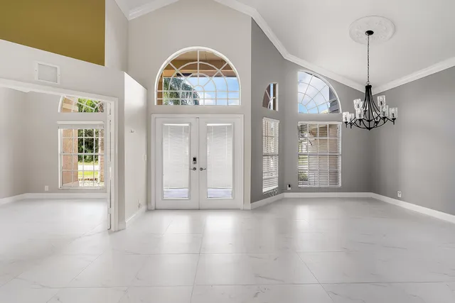 a view of a living room with kitchen island and a chandelier