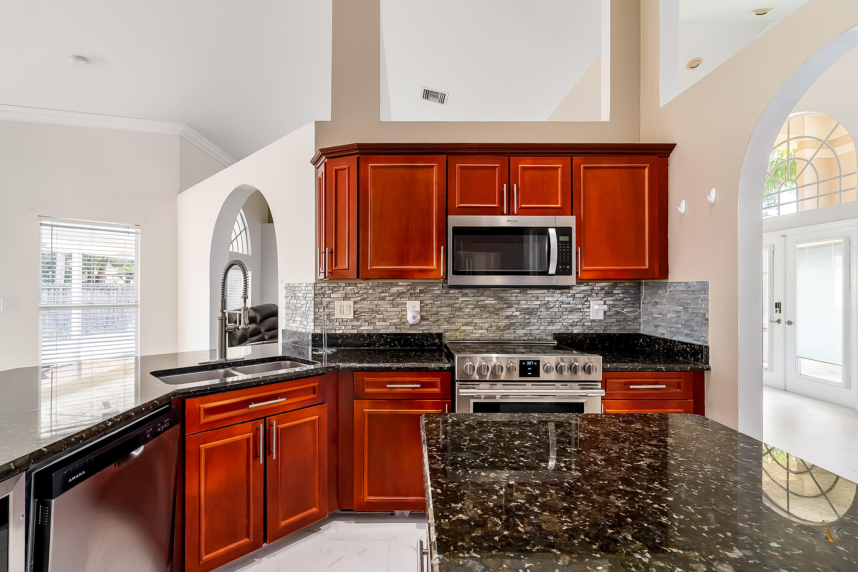 2962 Southwest Coastal Terrace Port St. Lucie, FL 34953 - Photo 29 of 59 a kitchen with stainless steel appliances granite countertop a stove and a sink