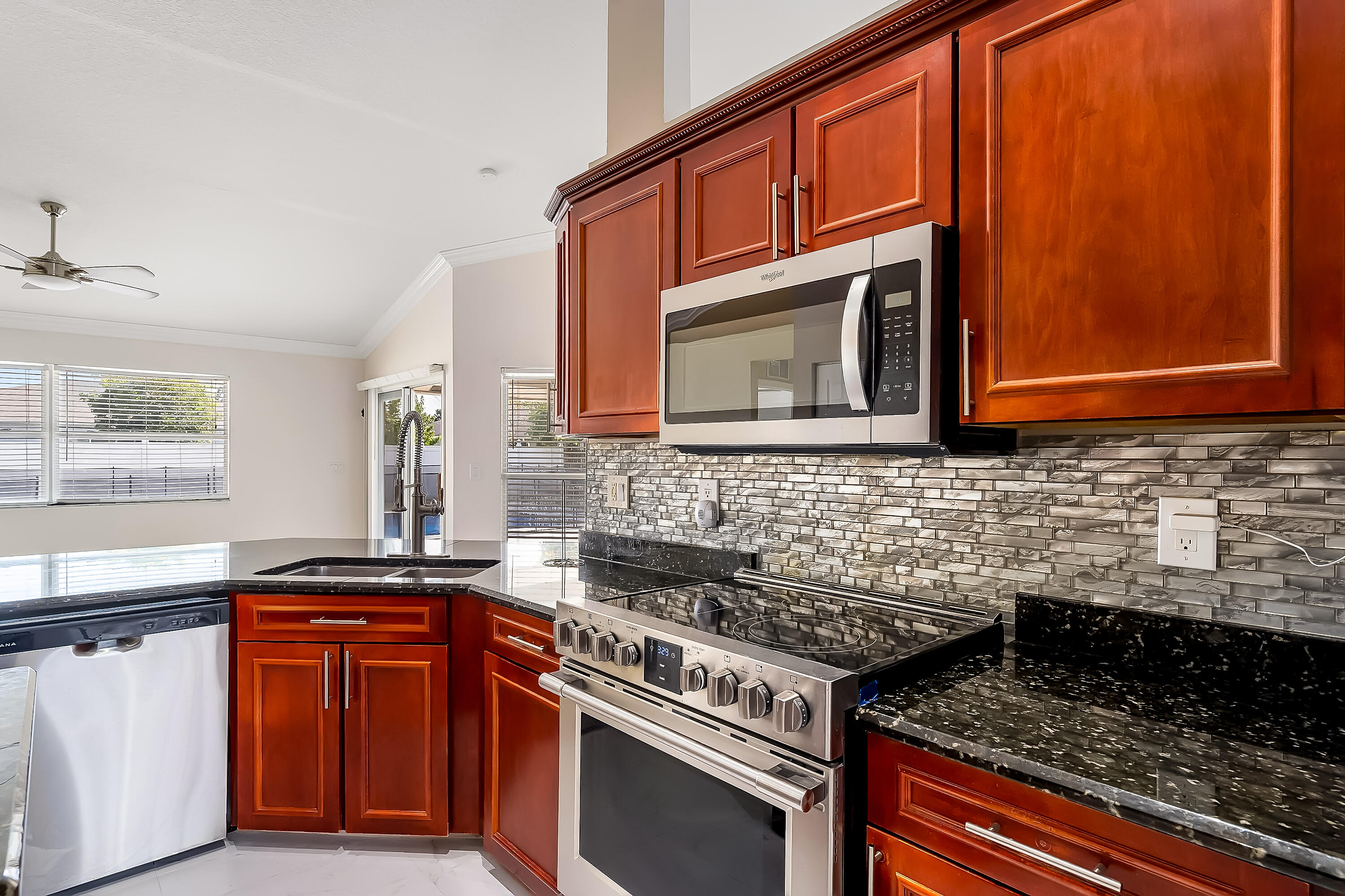 2962 Southwest Coastal Terrace Port St. Lucie, FL 34953 - Photo 32 of 59 a kitchen with granite countertop cabinets stove top oven and microwave