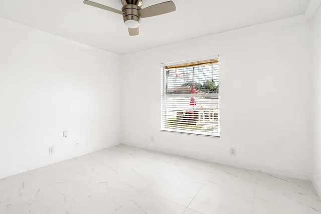 a view of a livingroom with a ceiling fan and window