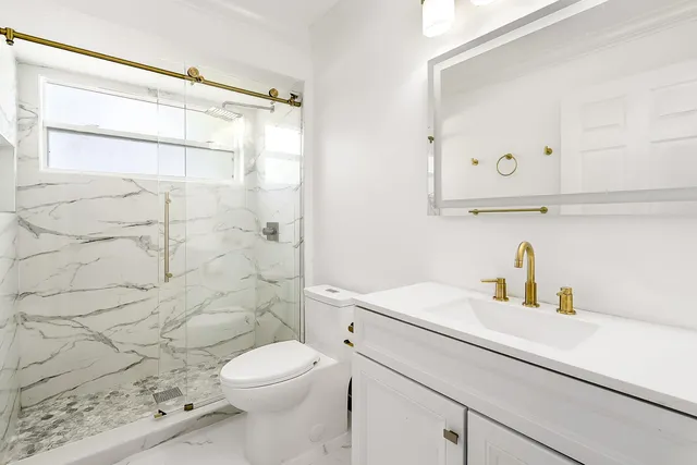 an empty room with chandelier fan and windows