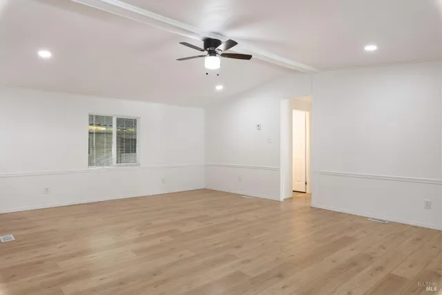 an empty room with fan and windows