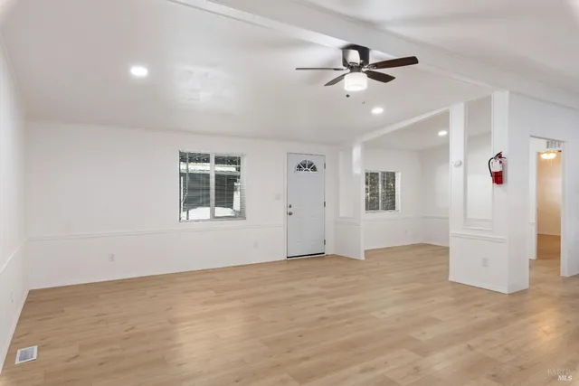 a view of an empty room with a ceiling fan