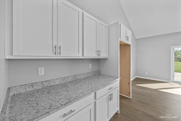 a kitchen with granite countertop white cabinets and sink