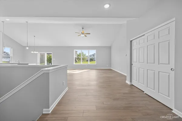 a view of an empty room with a window and wooden floor