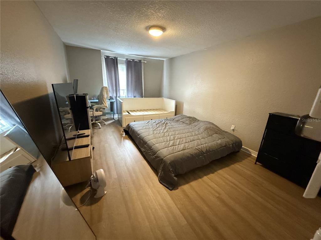 1928 South Conway Road, Unit 35 Orlando, FL 32812 - Photo 3 of 16 a bedroom with a bed and wooden floor