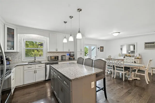 a kitchen with cabinets stainless steel appliances and wooden floor