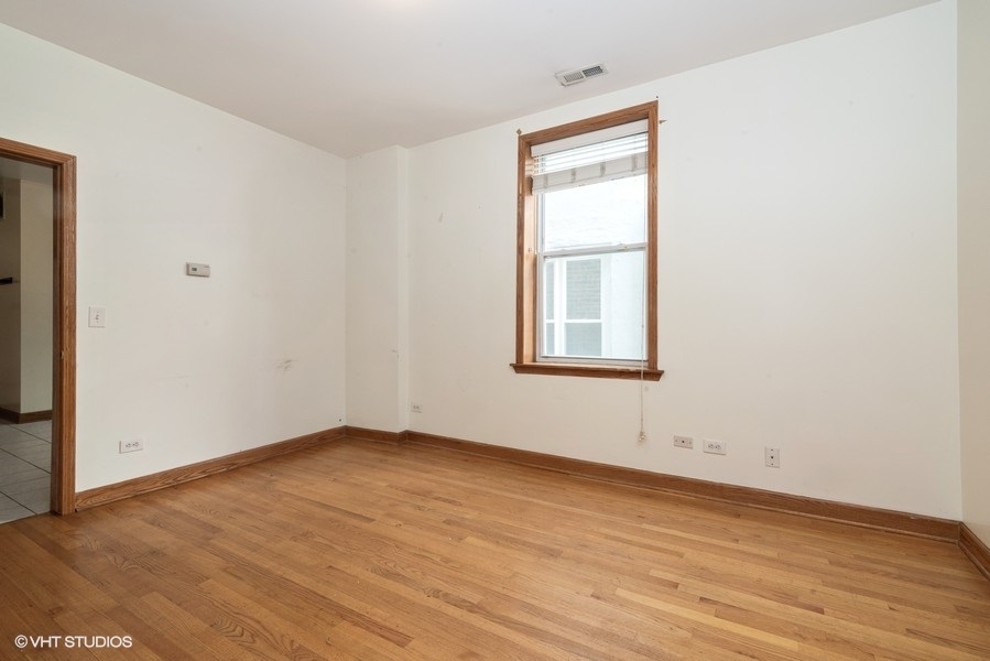 819 South Carpenter Street, Unit 1R Chicago, IL 60607 - Photo 3 of 6 an empty room with wooden floor and windows