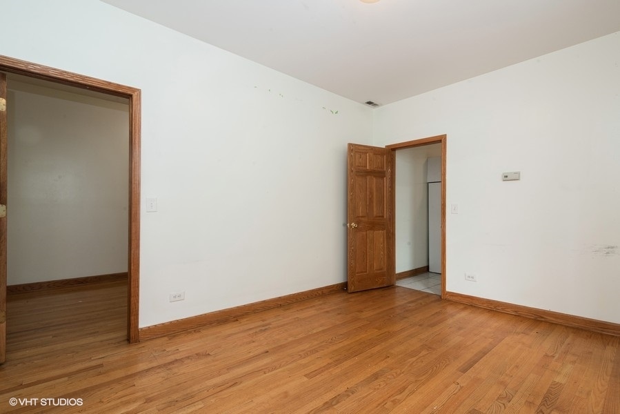 819 South Carpenter Street, Unit 1R Chicago, IL 60607 - Photo 5 of 6 a view of an empty room with wooden floor and closet
