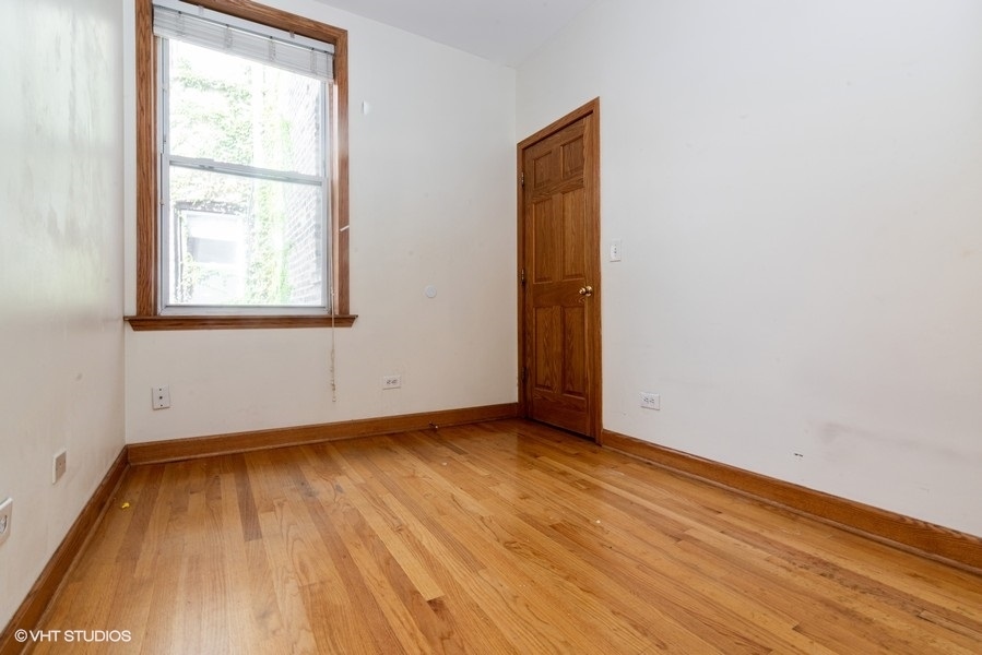 819 South Carpenter Street, Unit 1R Chicago, IL 60607 - Photo 6 of 6 an empty room with wooden floor and windows