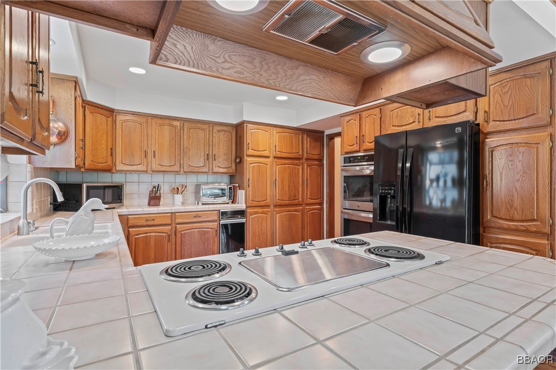 524 Golf Course Road Lake Arrowhead, CA 92352 - Photo 14 of 50 a kitchen with stainless steel appliances granite countertop a sink and cabinets
