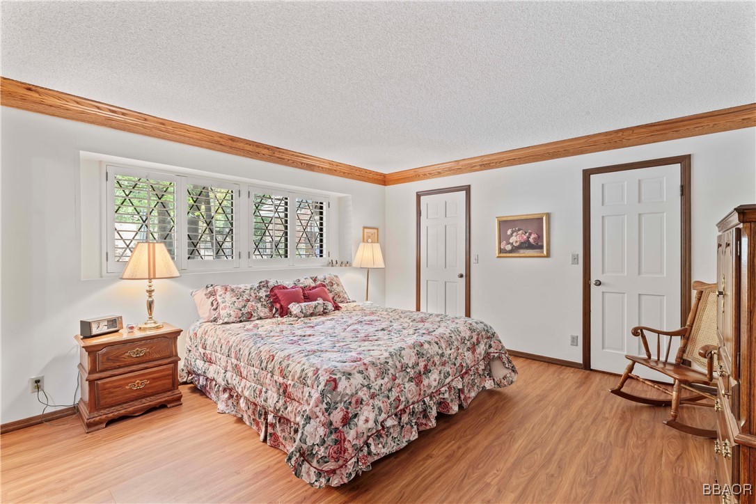 524 Golf Course Road Lake Arrowhead, CA 92352 - Photo 22 of 50 a bedroom with a bed and wooden floor