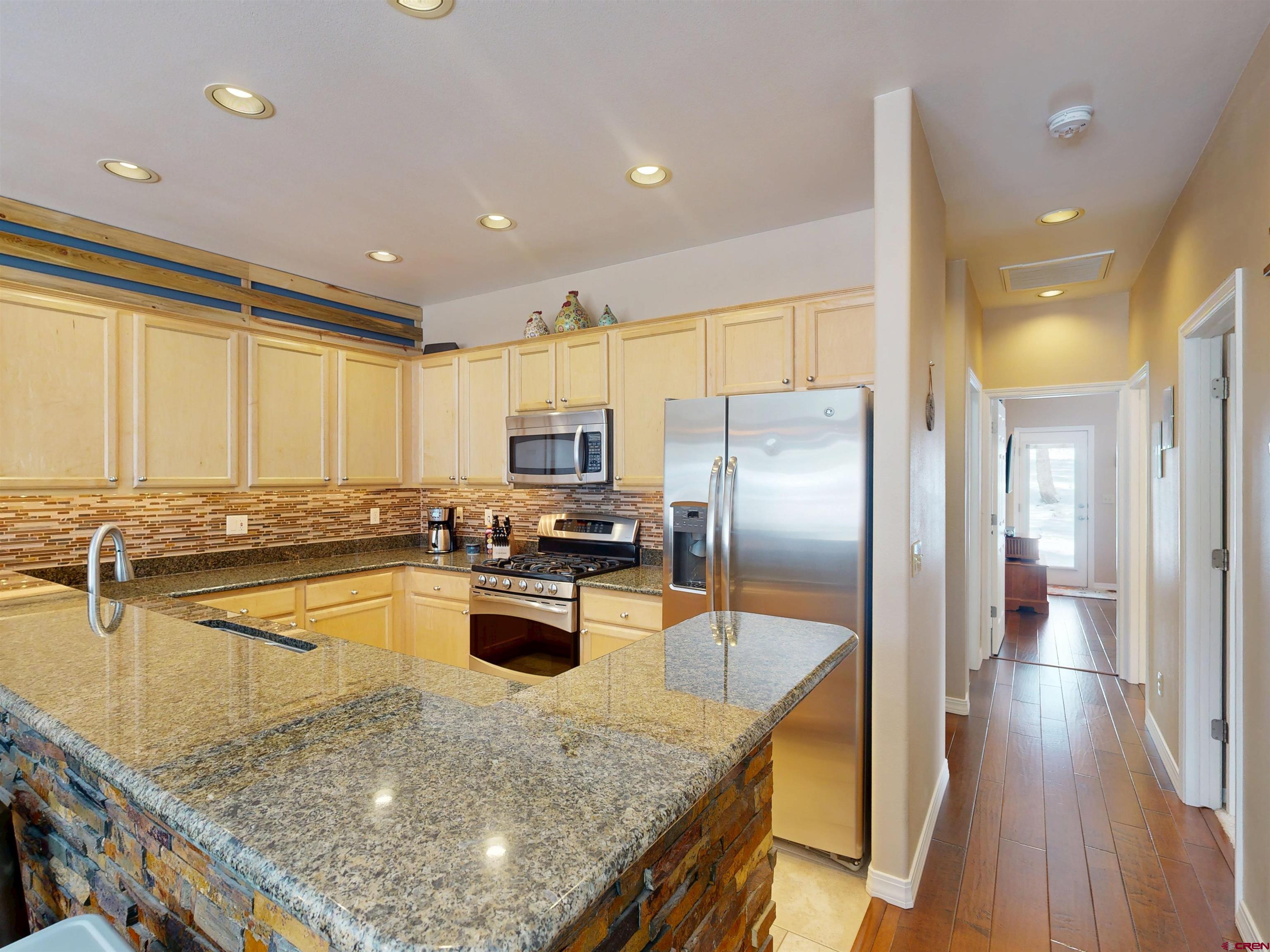 841 Woodbridge Way Durango, CO 81301 - Photo 22 of 27 a kitchen with stainless steel appliances granite countertop a sink a stove and a refrigerator