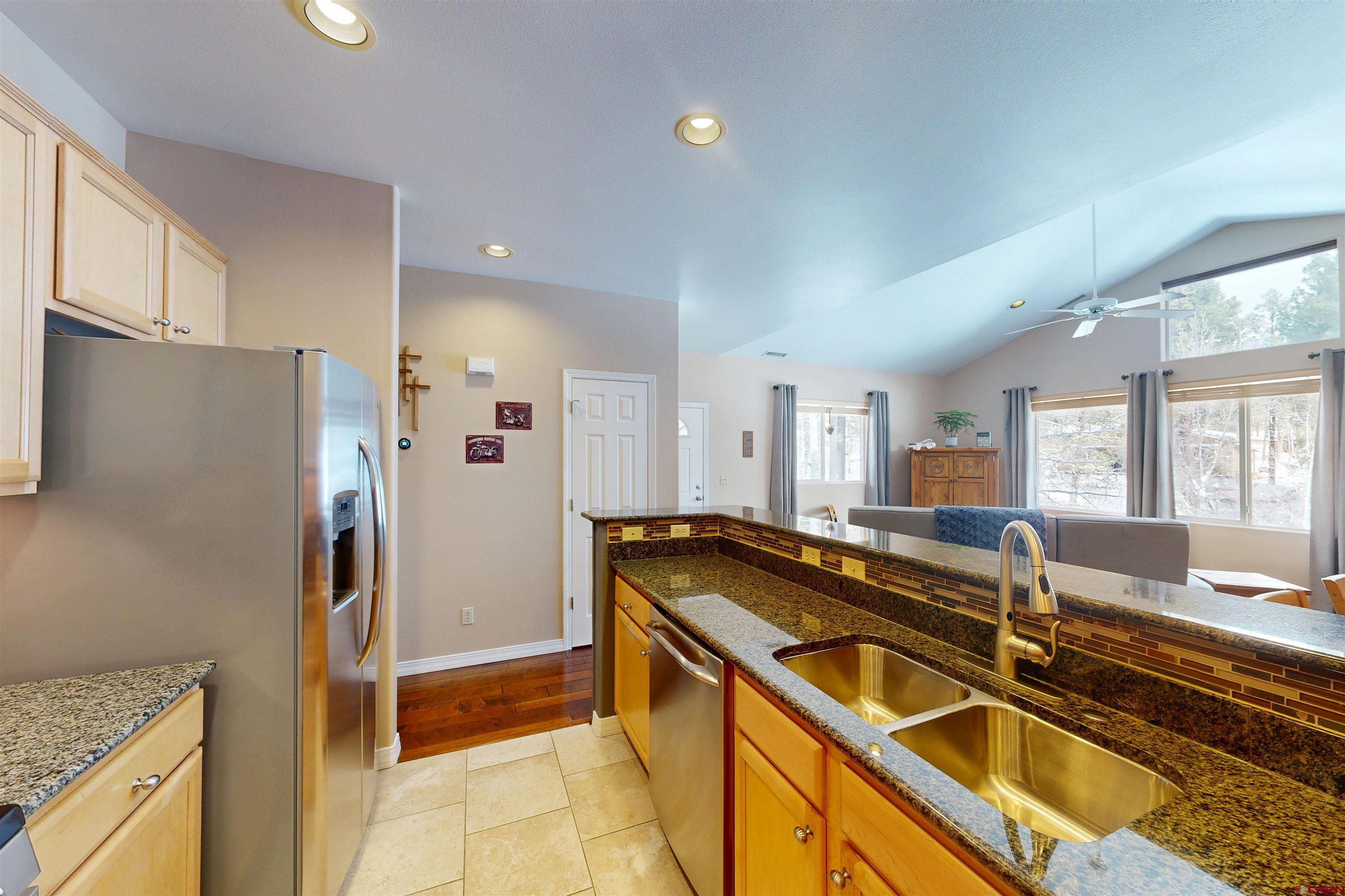 841 Woodbridge Way Durango, CO 81301 - Photo 23 of 27 a kitchen that has a sink a refrigerator and a stove top oven