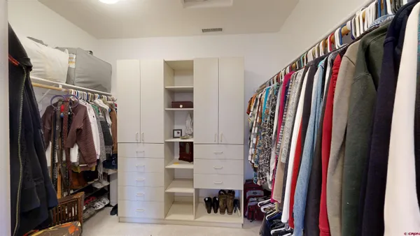 a view of walk in closet with clothes and shoes