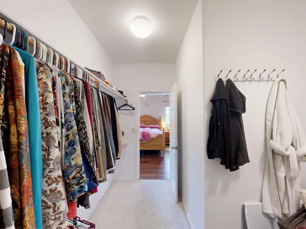 a view of walk in closet with clothes and shoes