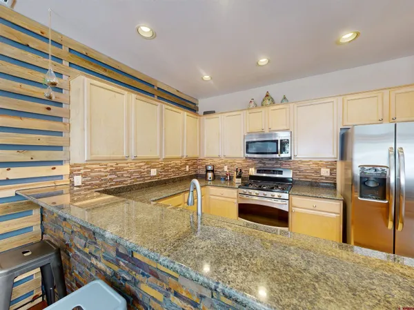 a kitchen with a refrigerator sink and stove top oven
