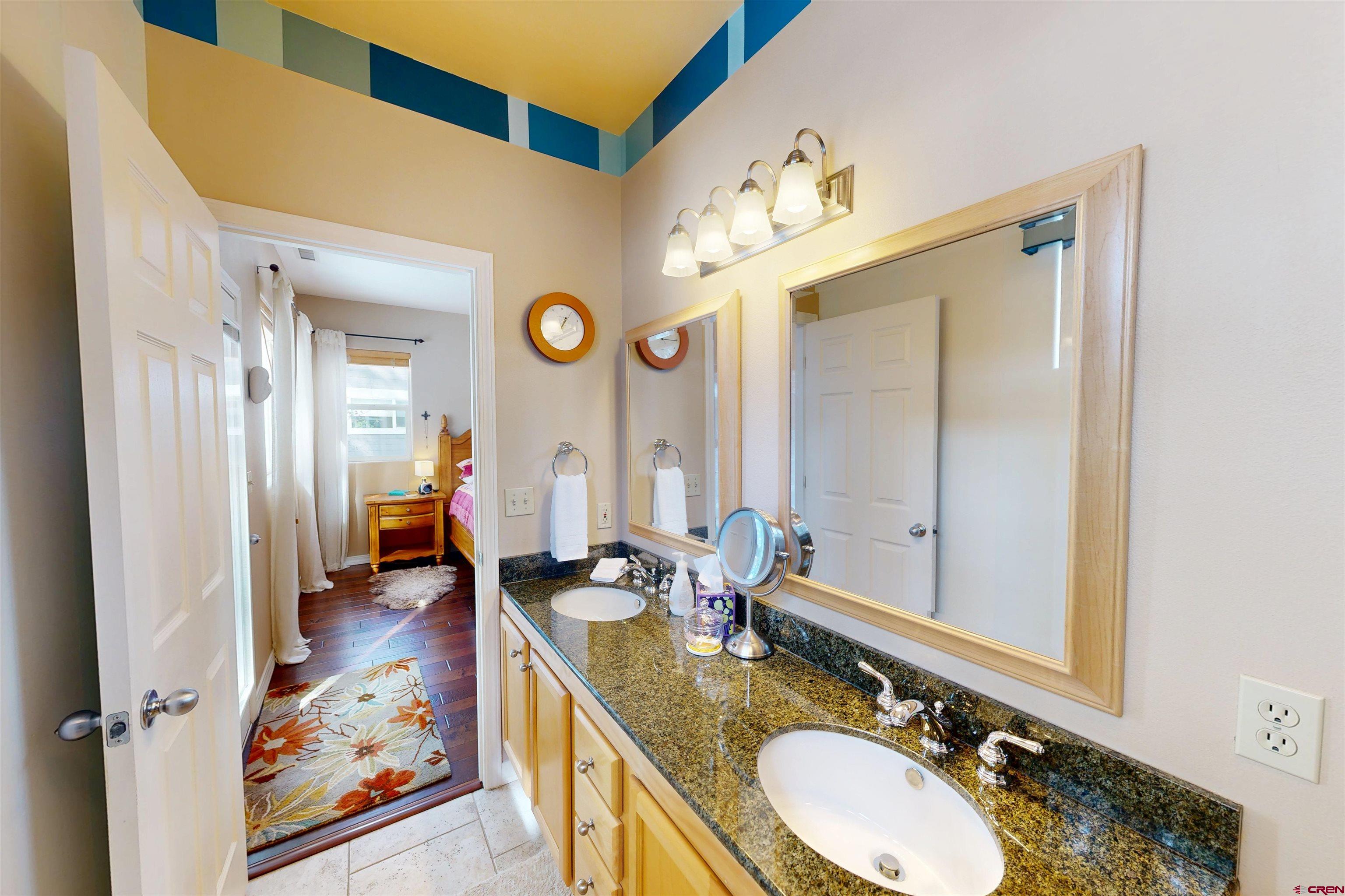 841 Woodbridge Way Durango, CO 81301 - Photo 8 of 27 a en suite bathroom with a granite countertop double vanity sink and a mirror