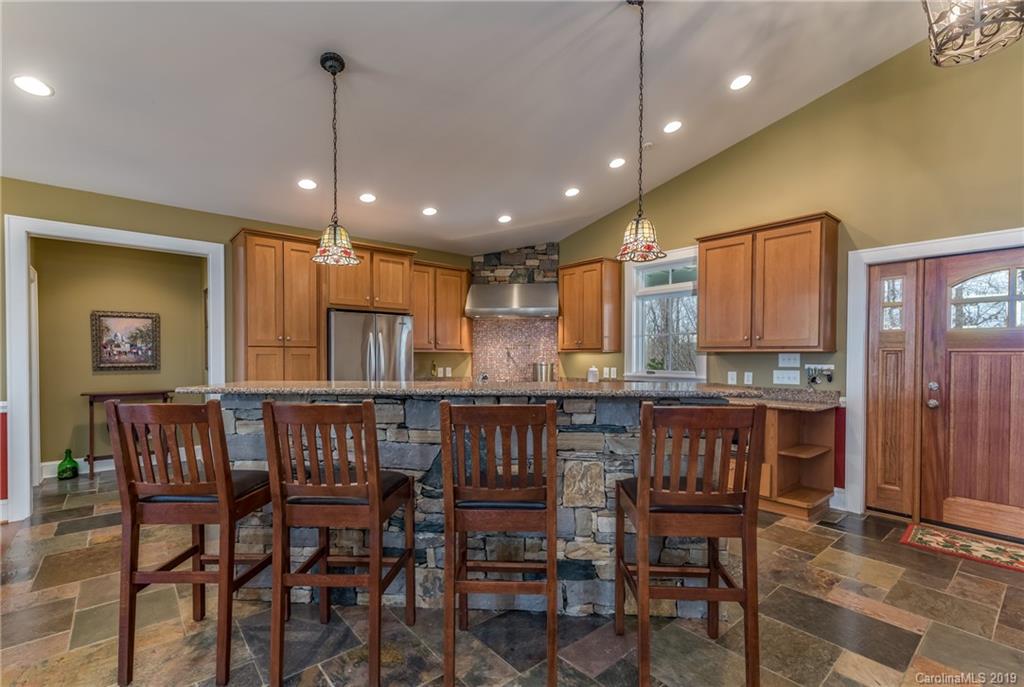 1723 Clark Road Rutherfordton, NC 28139 - Photo 8 of 37 a large kitchen with a dining table chairs wooden cabinets and stainless steel appliances