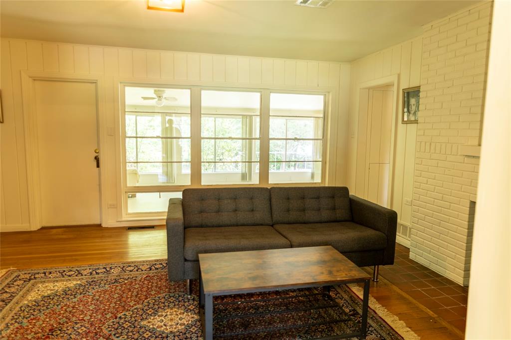 3228 Colcord Avenue Waco, TX 76707 - Photo 5 of 29 Spacious interior featuring a brick fireplace, wood-finish flooring, and expansive windows