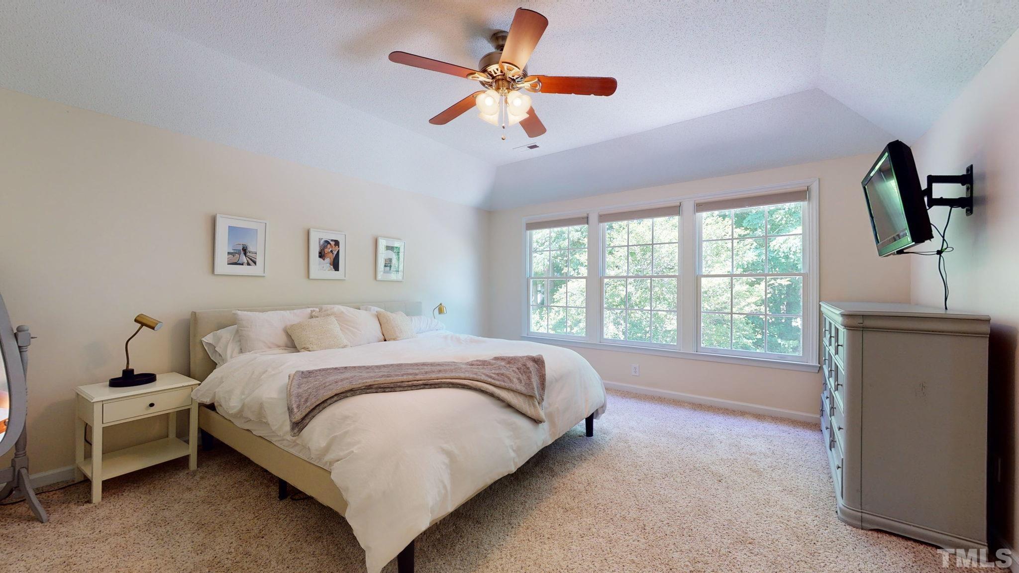 7900 Broad Street Raleigh, NC 27613 - Photo 29 of 53 a spacious bedroom with a bed a chandelier and a window