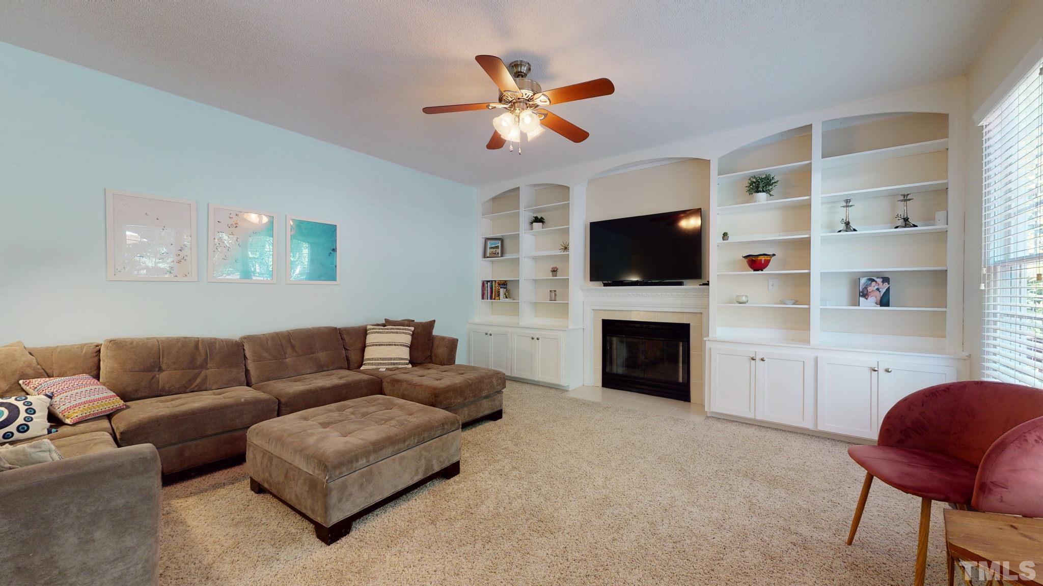 7900 Broad Street Raleigh, NC 27613 - Photo 7 of 53 a living room with furniture a fireplace and a flat screen tv