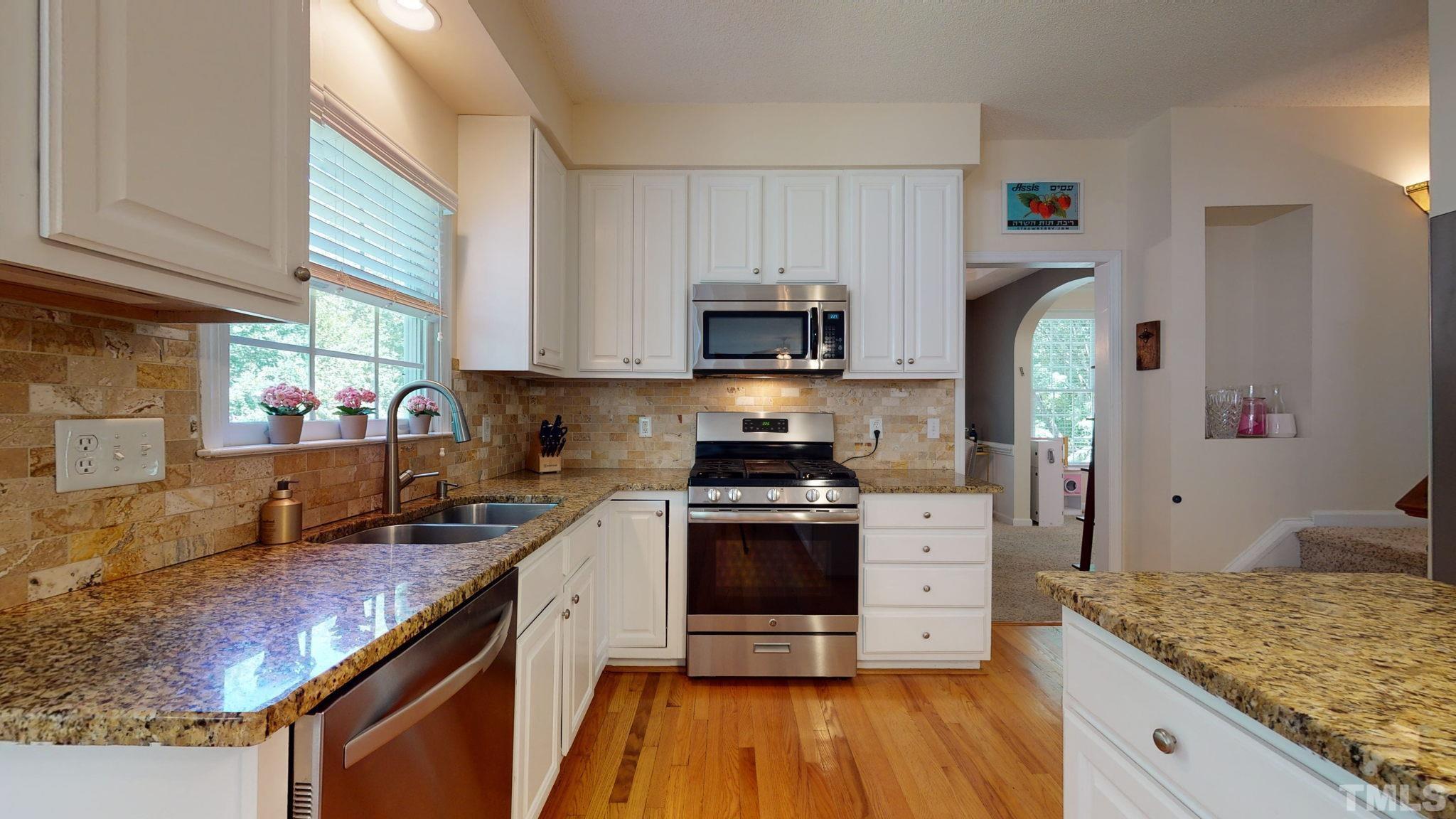 7900 Broad Street Raleigh, NC 27613 - Photo 10 of 53 a kitchen with stainless steel appliances granite countertop a stove a sink and a refrigerator