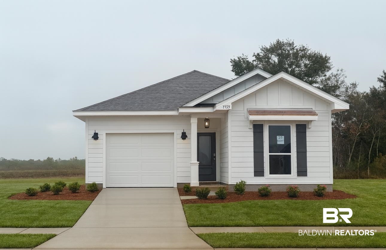 View of front of house featuring board and batten siding, a front lawn, a shingled roof, driveway, and an attached garage