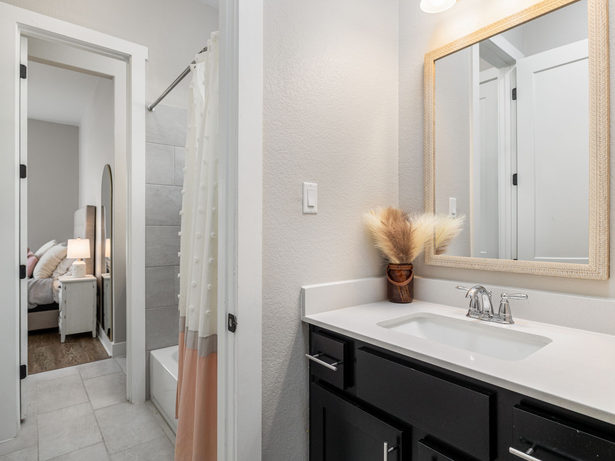 901 Clark Cove Road Buda, TX 78610 - Photo 11 of 37 Full bath with vanity, shower / bath combo with shower curtain, a textured wall, and light tile patterned floors