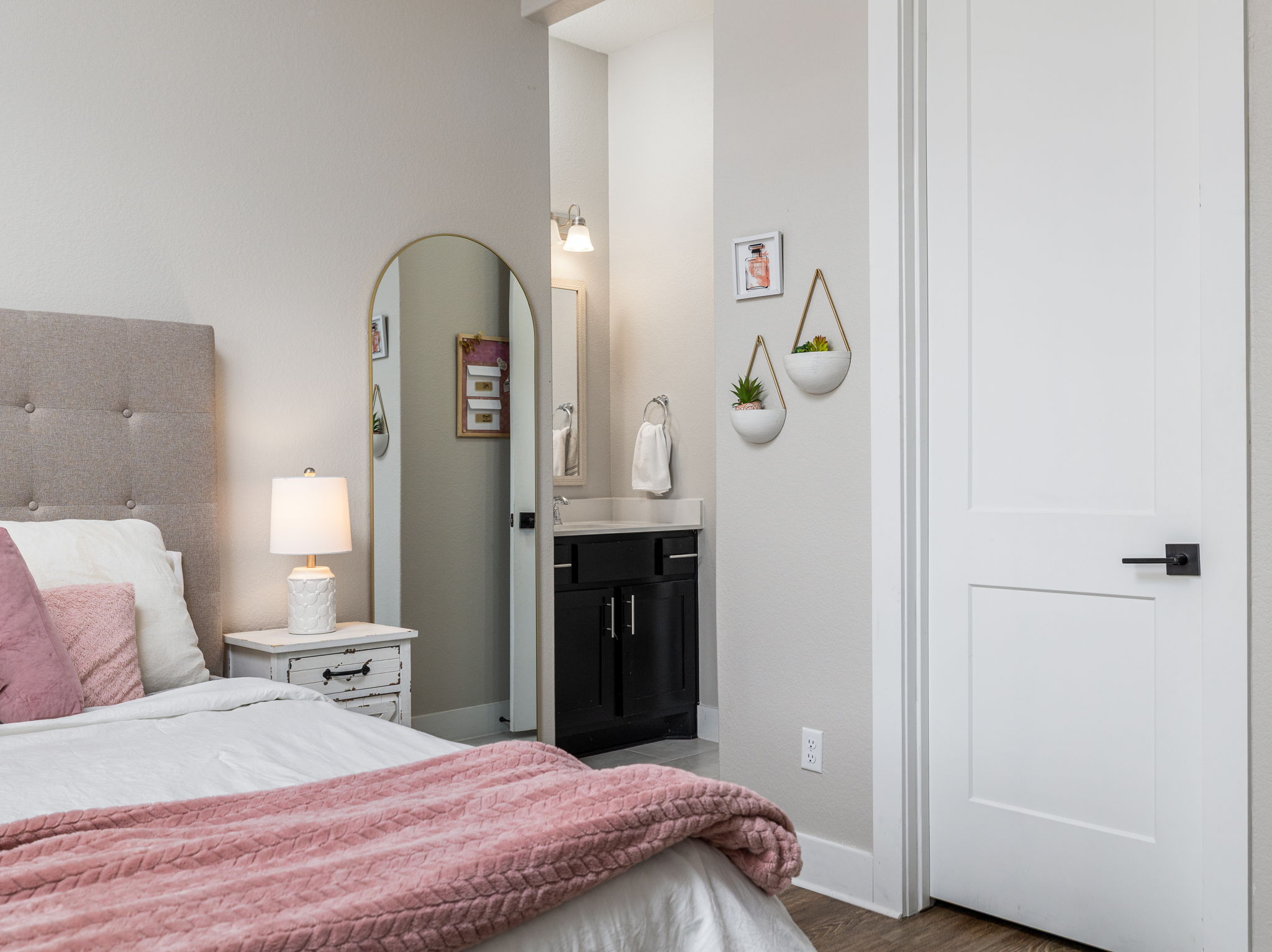 901 Clark Cove Road Buda, TX 78610 - Photo 13 of 37 Bedroom featuring arched walkways, dark wood-style flooring, and ensuite bathroom
