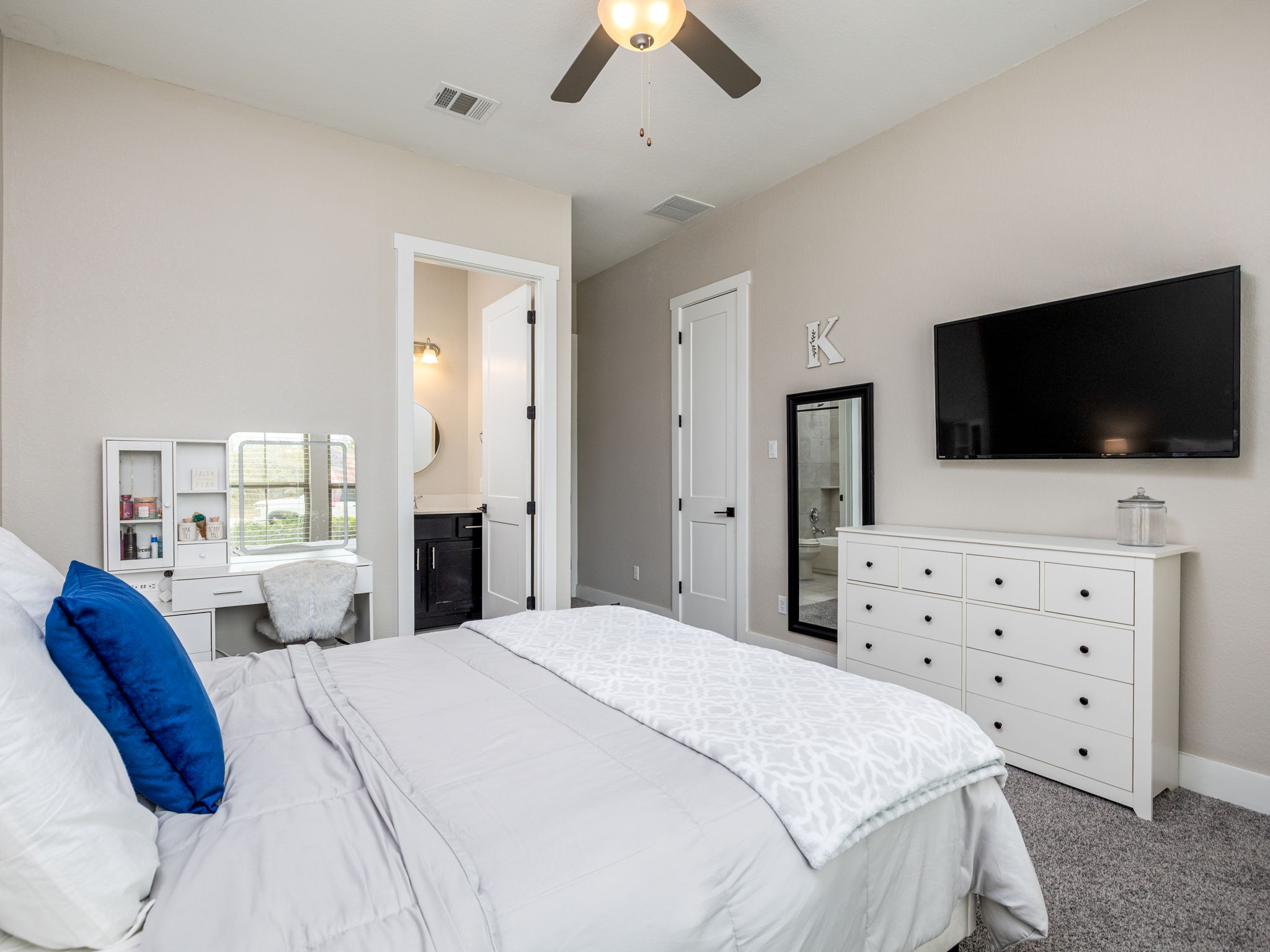 901 Clark Cove Road Buda, TX 78610 - Photo 15 of 37 Bedroom with carpet, ceiling fan, and ensuite bathroom