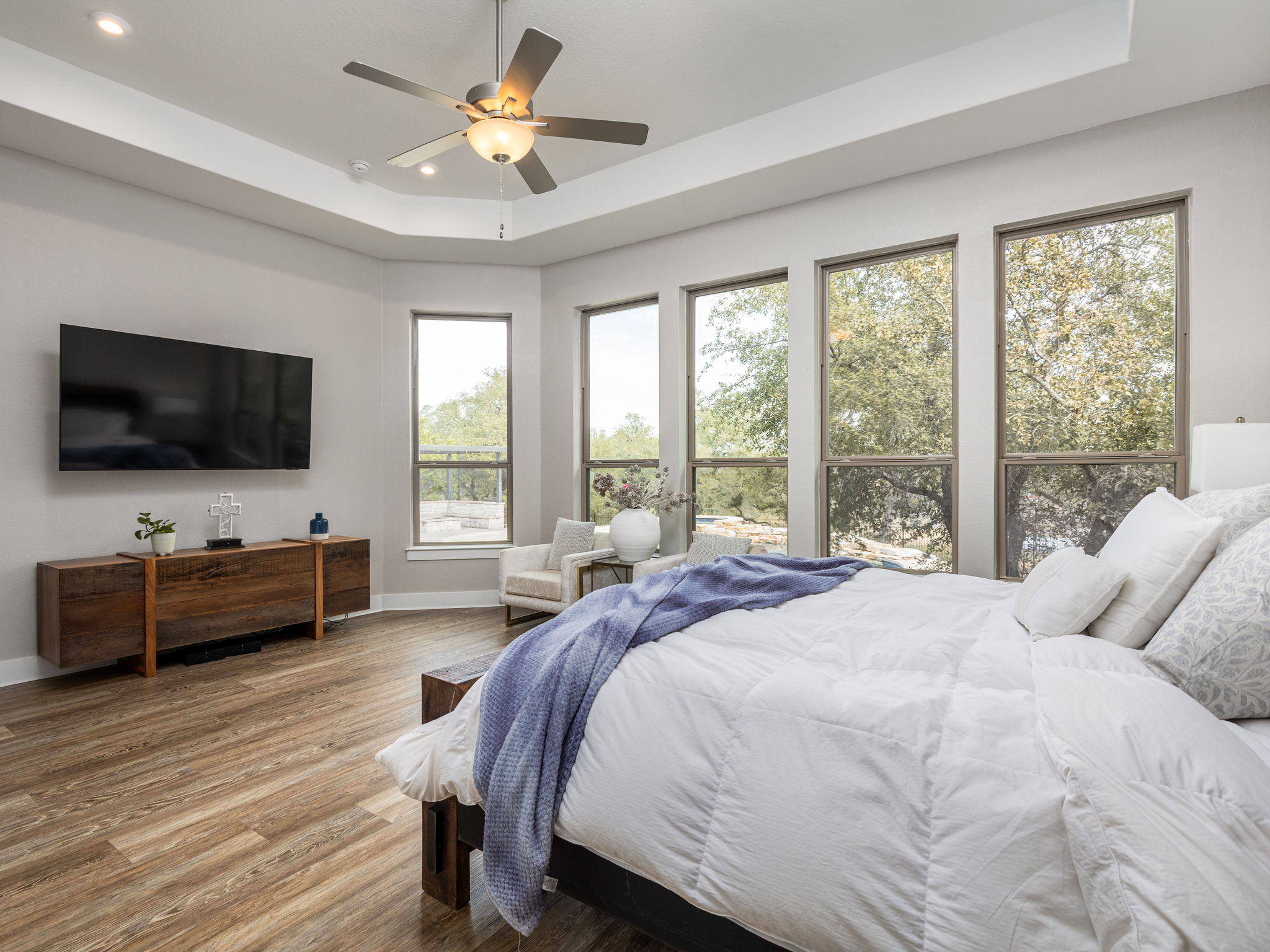 901 Clark Cove Road Buda, TX 78610 - Photo 17 of 37 Bedroom featuring a tray ceiling, light wood finished floors, ceiling fan, and recessed lighting