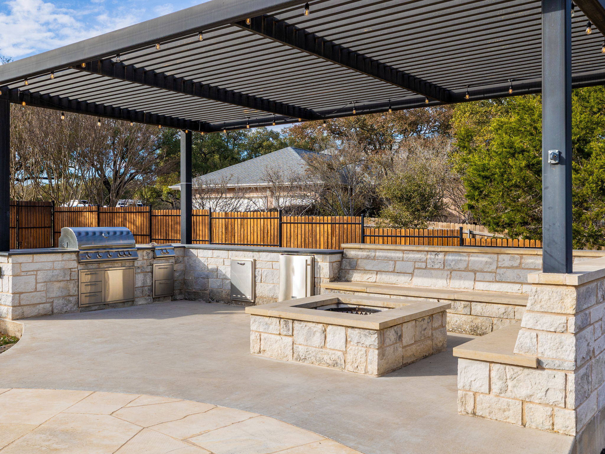 901 Clark Cove Road Buda, TX 78610 - Photo 30 of 37 Fenced backyard featuring an outdoor kitchen, a pergola, a patio, and an outdoor fire pit
