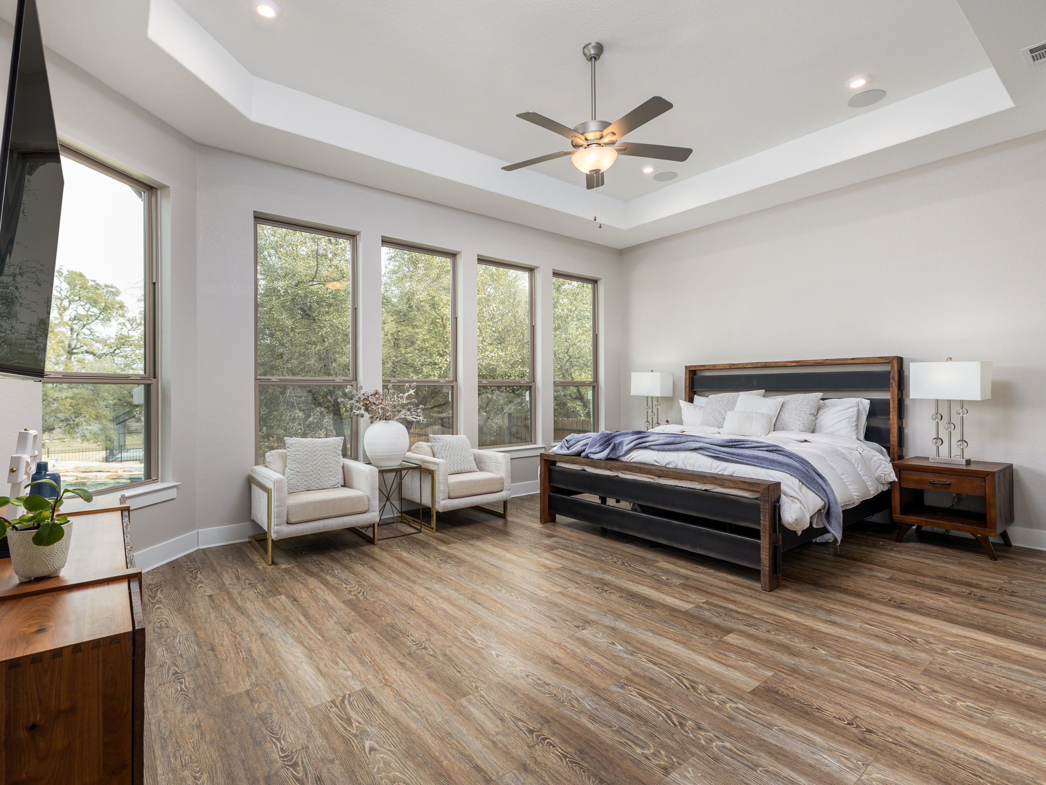 901 Clark Cove Road Buda, TX 78610 - Photo 7 of 37 Bedroom featuring a raised ceiling, light wood finished floors, and ceiling fan