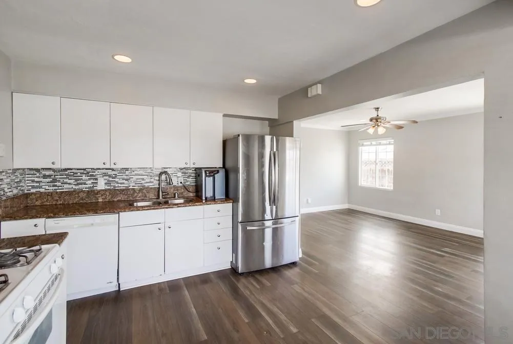 6327 Newsome Drive San Diego, CA 92115 - Photo 8 of 24 a kitchen with granite countertop a refrigerator and a stove top oven