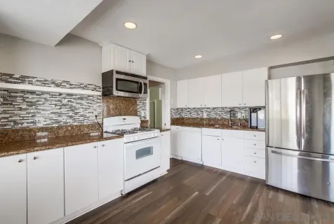 a kitchen with granite countertop stainless steel appliances and wooden cabinets