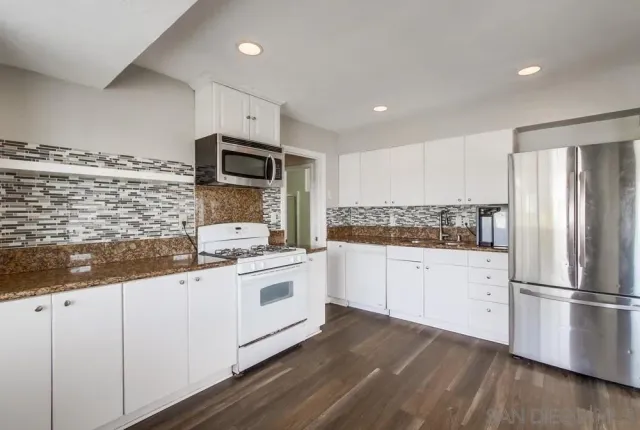a kitchen with granite countertop stainless steel appliances and wooden cabinets
