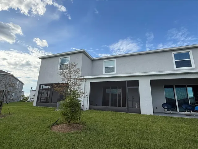 a view of a house with potted plants and a yard