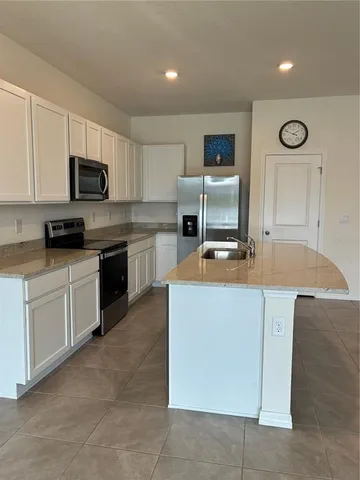 a kitchen with stainless steel appliances granite countertop a stove top oven a sink a counter top space and cabinets