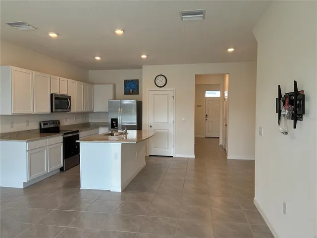 a kitchen with a refrigerator and a stove top oven
