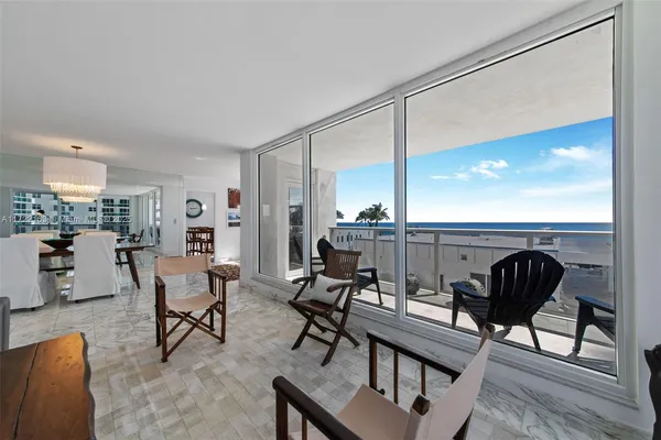 a living room with furniture and a view of kitchen