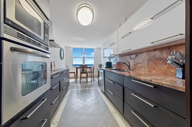 a kitchen with stainless steel appliances granite countertop a stove a sink and a refrigerator