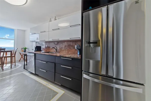 a kitchen with stainless steel appliances granite countertop a refrigerator and a sink