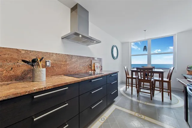 a kitchen with granite countertop a table chairs stove and cabinets