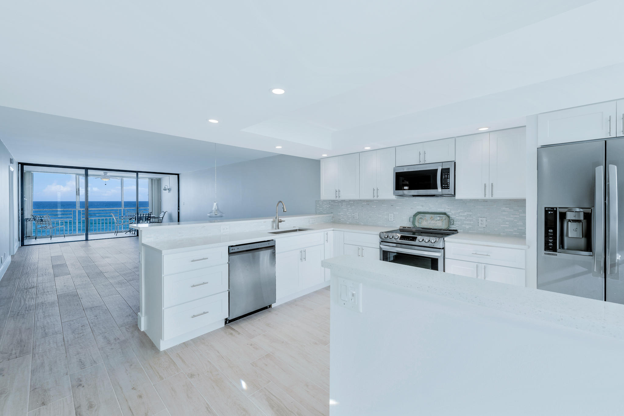 900 Ocean Drive, Unit 403 Juno Beach, FL 33408 - Photo 4 of 15 a kitchen with white cabinets and appliances