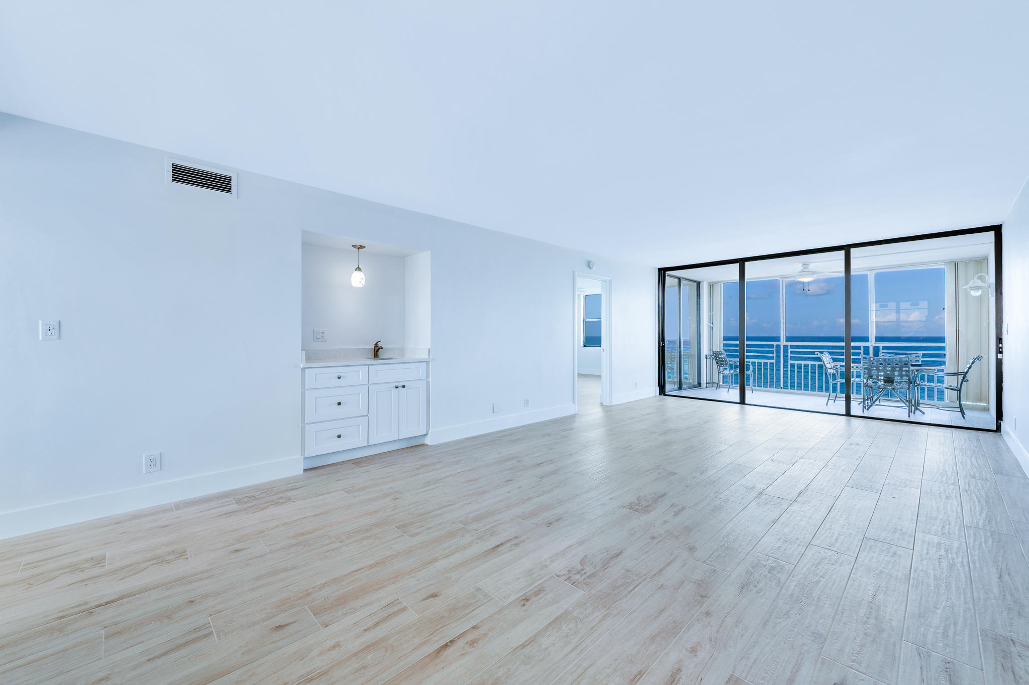 900 Ocean Drive, Unit 403 Juno Beach, FL 33408 - Photo 6 of 15 a view of an empty room with wooden floor and a window