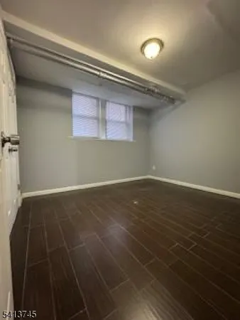 an empty room with wooden floor and cabinet