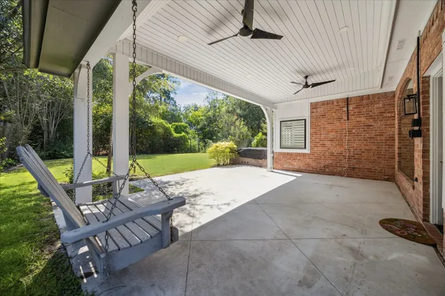 an empty room with wooden floor fireplace and windows