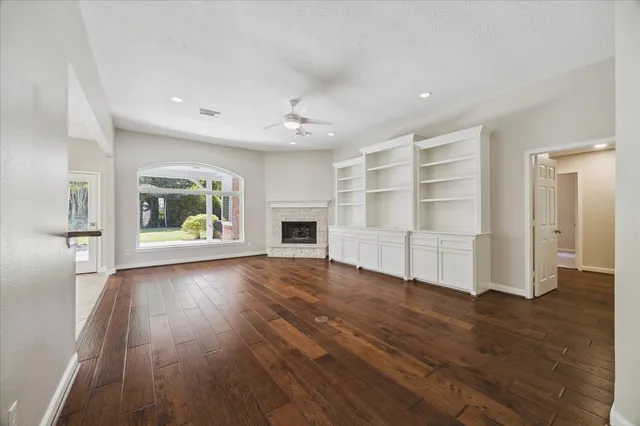 a large white kitchen with granite countertop a stove top oven a sink a dining table and chairs