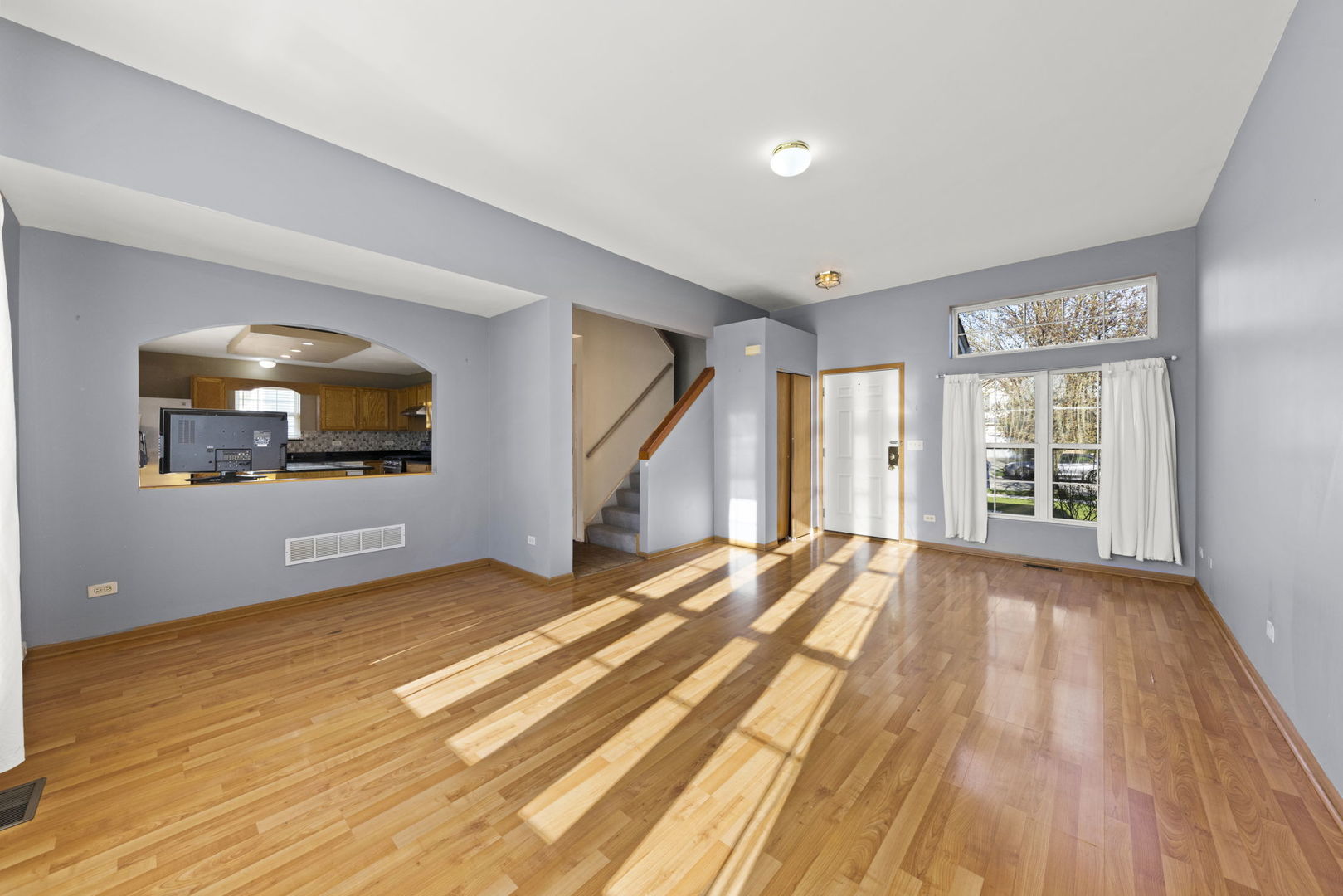 89 Iris Circle Romeoville, IL 60446 - Photo 3 of 28 a view of an empty room with wooden floor and a window